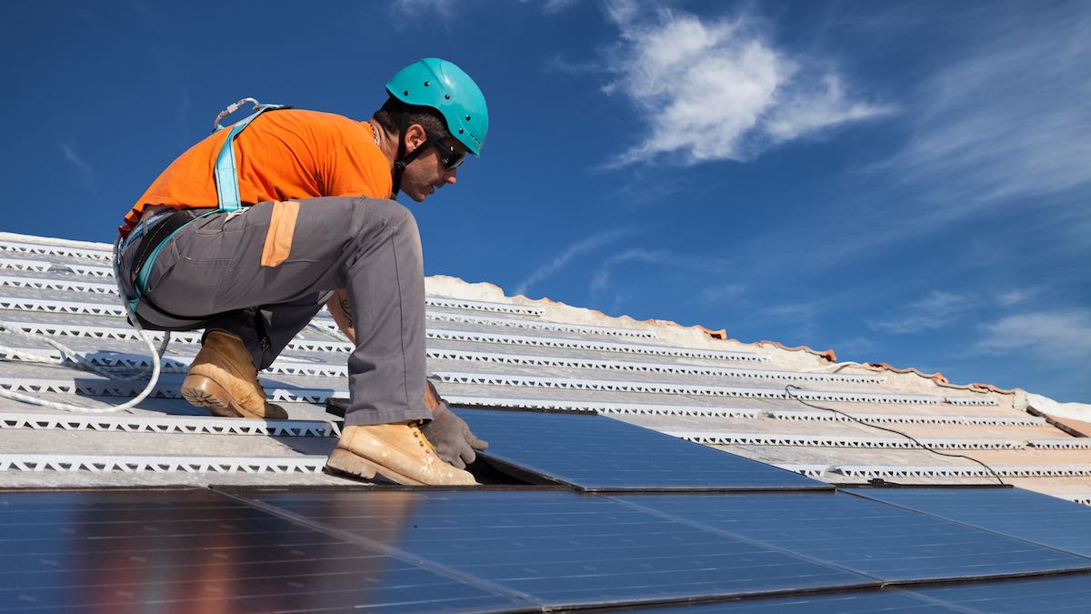A local solar contractor installing solar panels on a sloped, residential roof